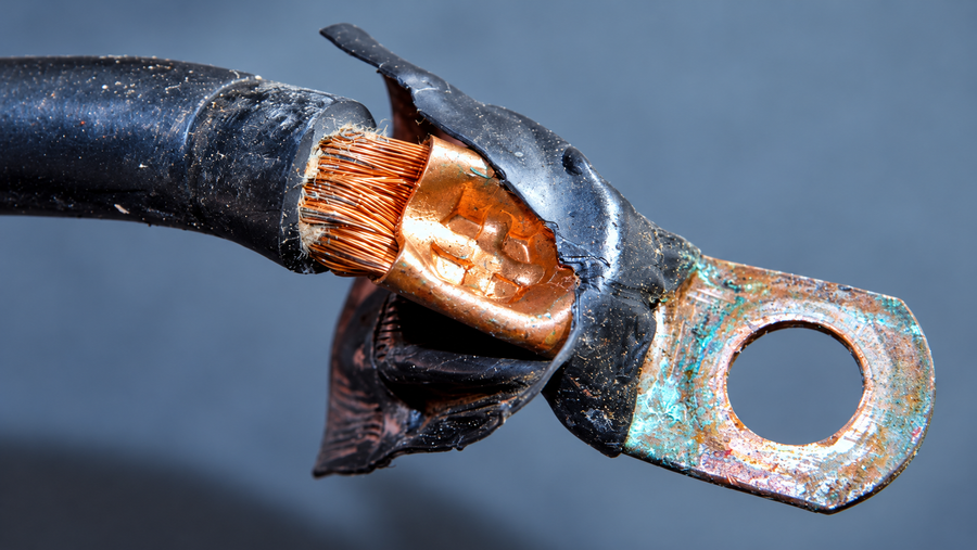 A disconnected marine cable lug shows corrosion on its exposed metal surface