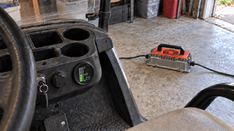 Utility cart battery gauge still showing a partial charge beside a charger that has stopped